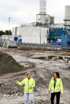 Two persons infront of a factory and building site