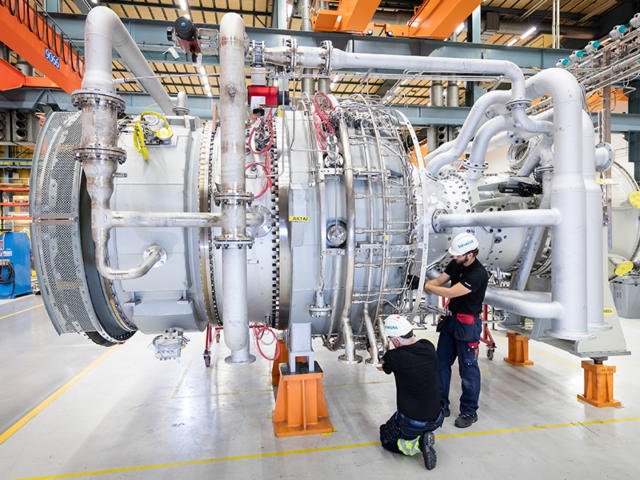 Two persons building a turbine