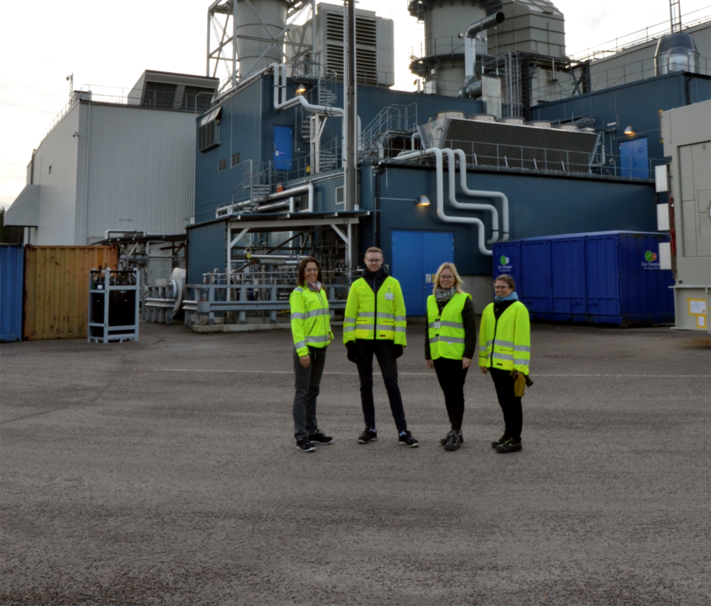 Four persons infront of a factory